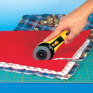 Photo showing 60mm OLFA rotary cutter in action cutting multiple layers of fabric