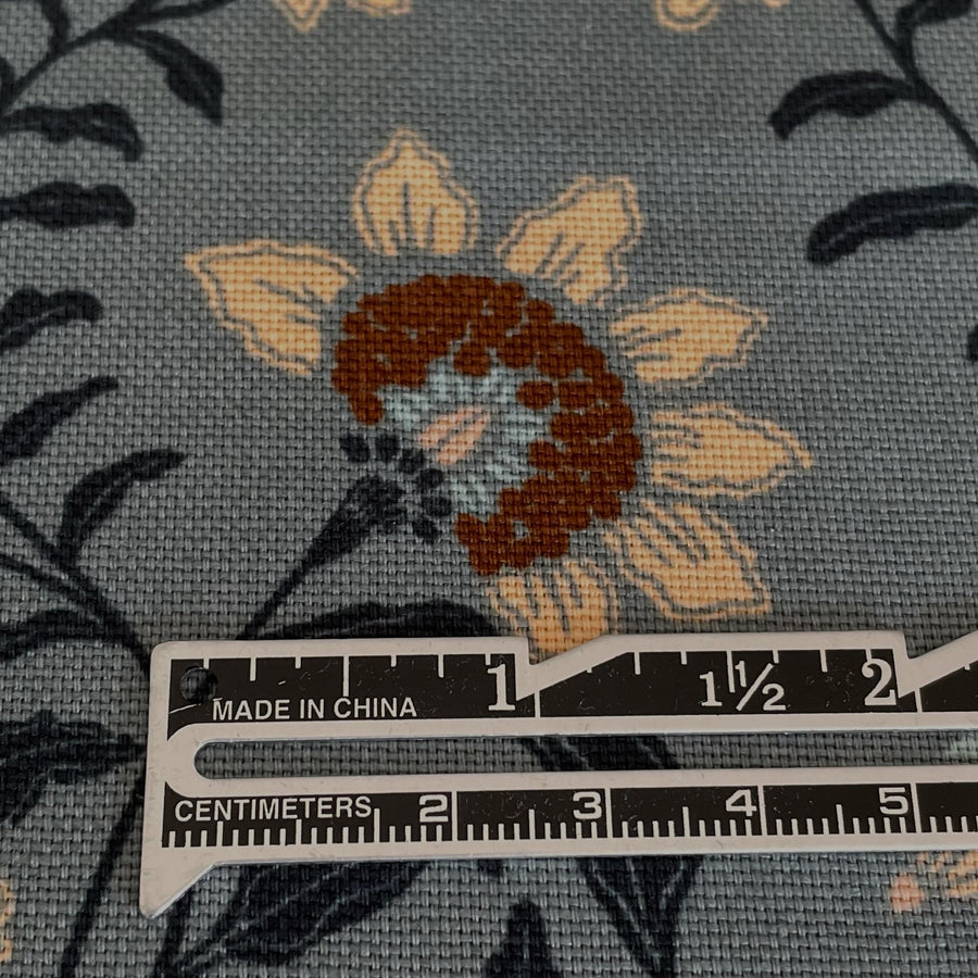 waterproof floral canvas fabric on a slate grey blue backgroun. Pretty flowers that look embroidered on