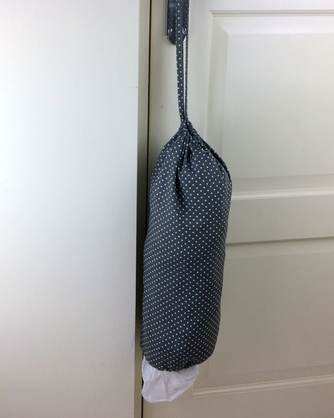 plastic bag dispenser and holder for those pesky bags for life that take over this one is a grey spotted canvas fabric