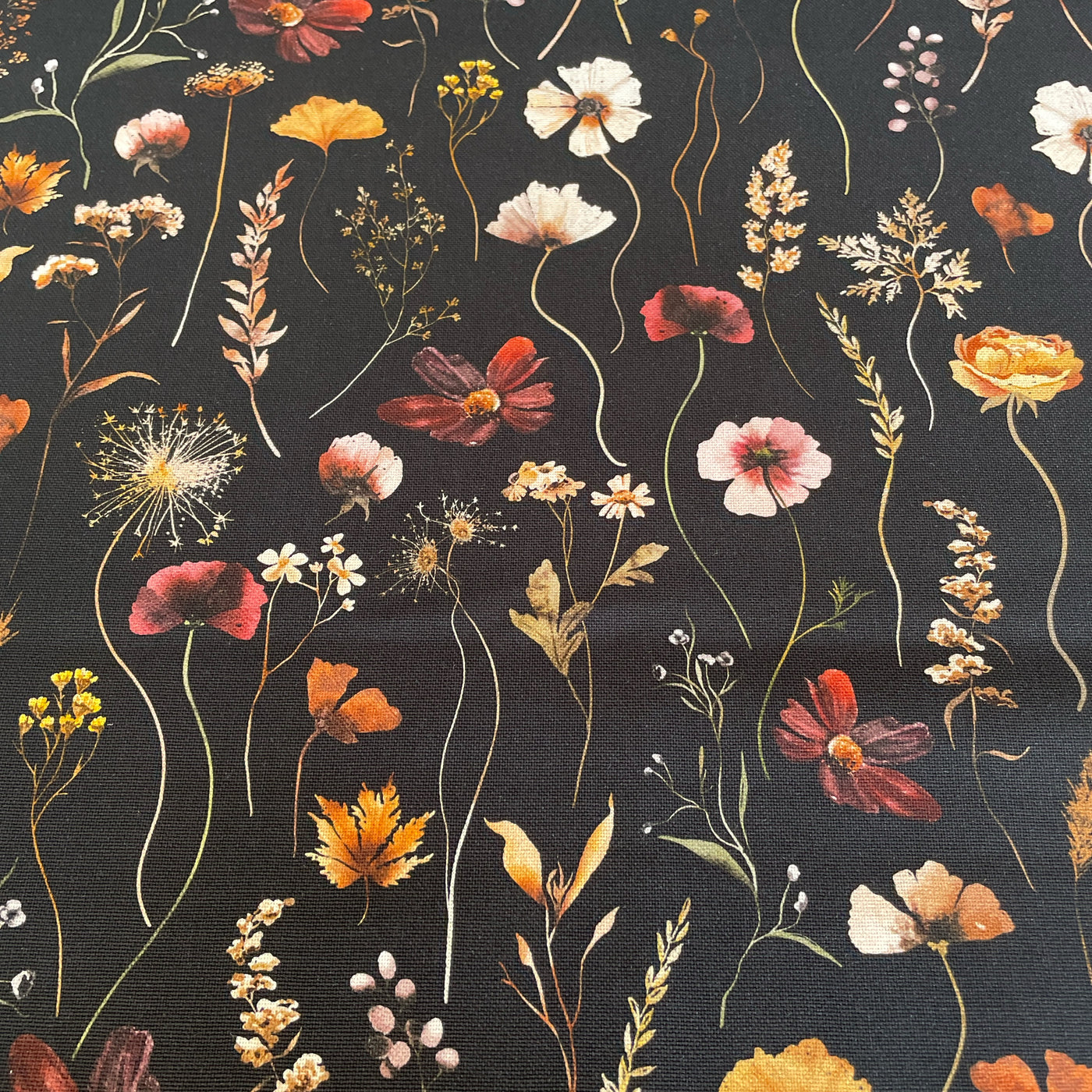 black canvas cotton fabric with a variety of flowers