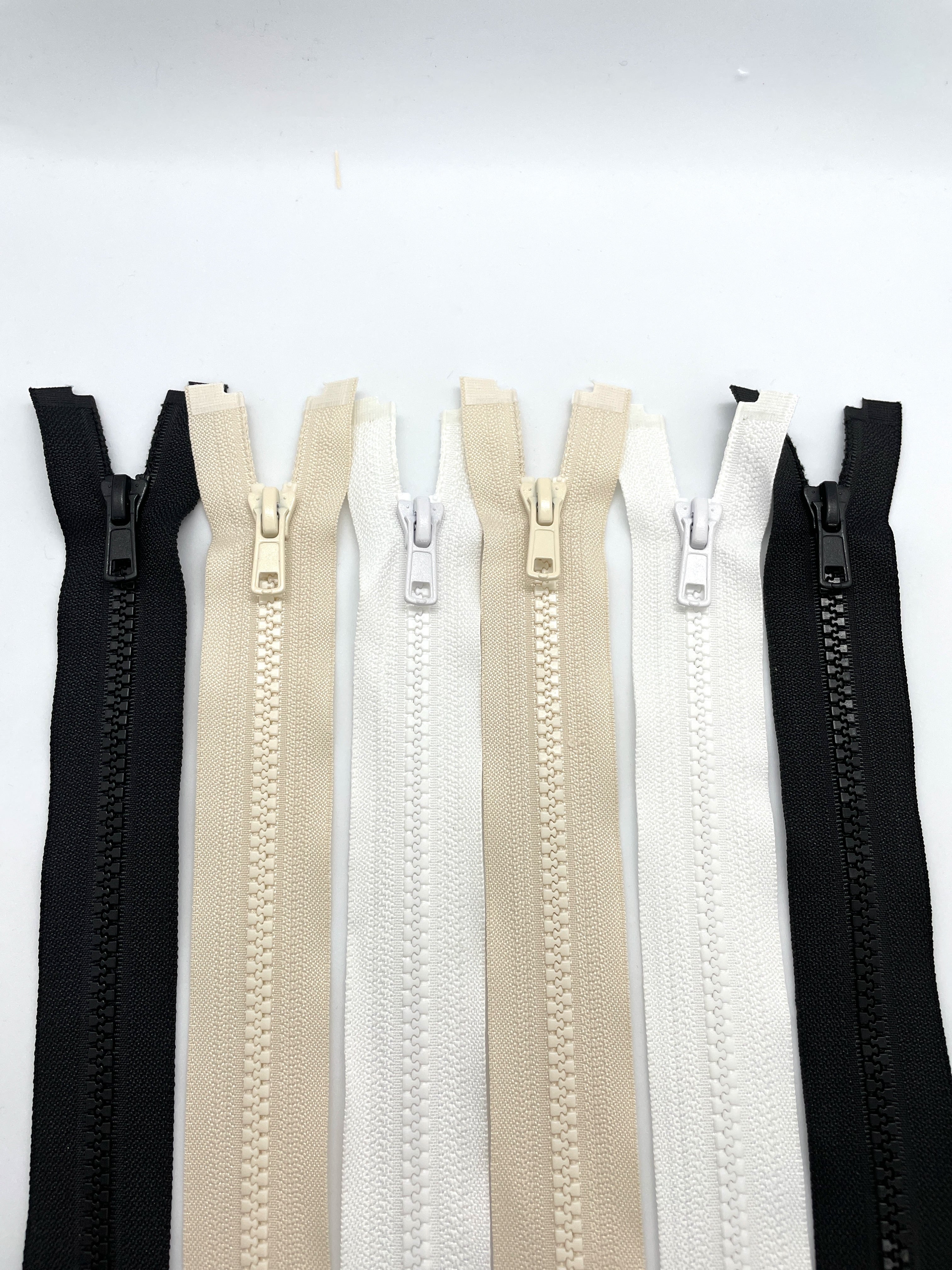 Chunky open zippers in black, white and neutral colours