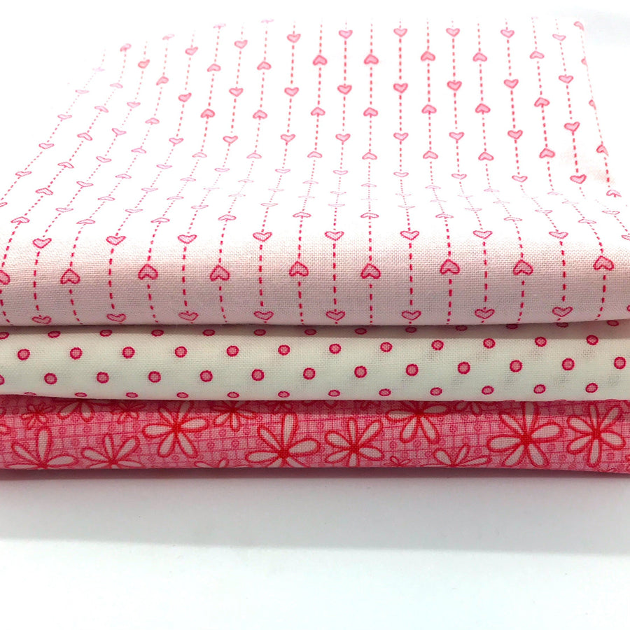 Photo of pink fat quarter bundles in the basically hugs red rooster collection