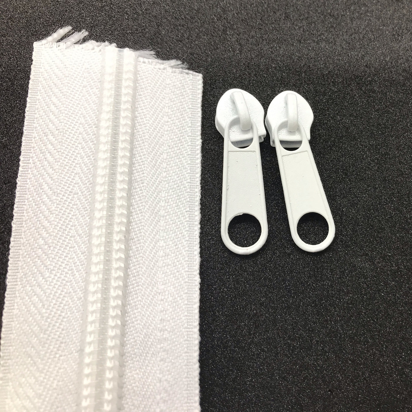 Photo of ivory continuous zipper rolls in size  5, available in various colors. Matching sliders/zipper heads included at 2 per meter. Size 5 refers to the size of the coils when closed at 5mm