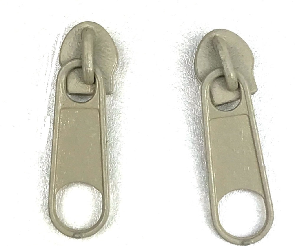 Beige Continuous standard zipper tape and sliders with pullers: Versatile zipper components designed for various applications. The continuous tape allows for customizable lengths, while the sliders and pullers ensure smooth operation and secure closure. Ideal for a wide range of projects, from apparel to accessories, offering functionality and durability. Upgrade your designs with dependable standard zipper tape and sliders complete with convenient pullers