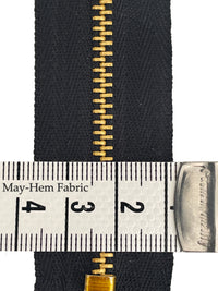 Close up of black metal jeans zip with tape measure showing the teeth size