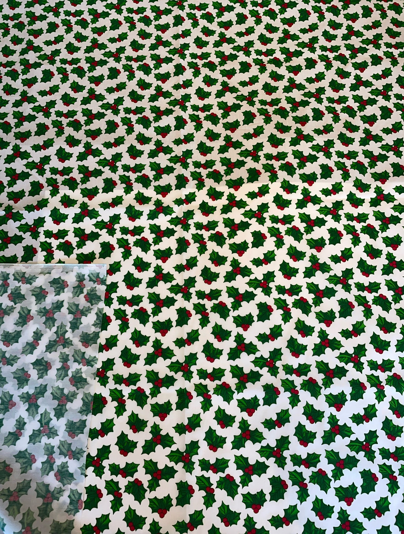 Patterned fabric with holly leaves and berries on a white background