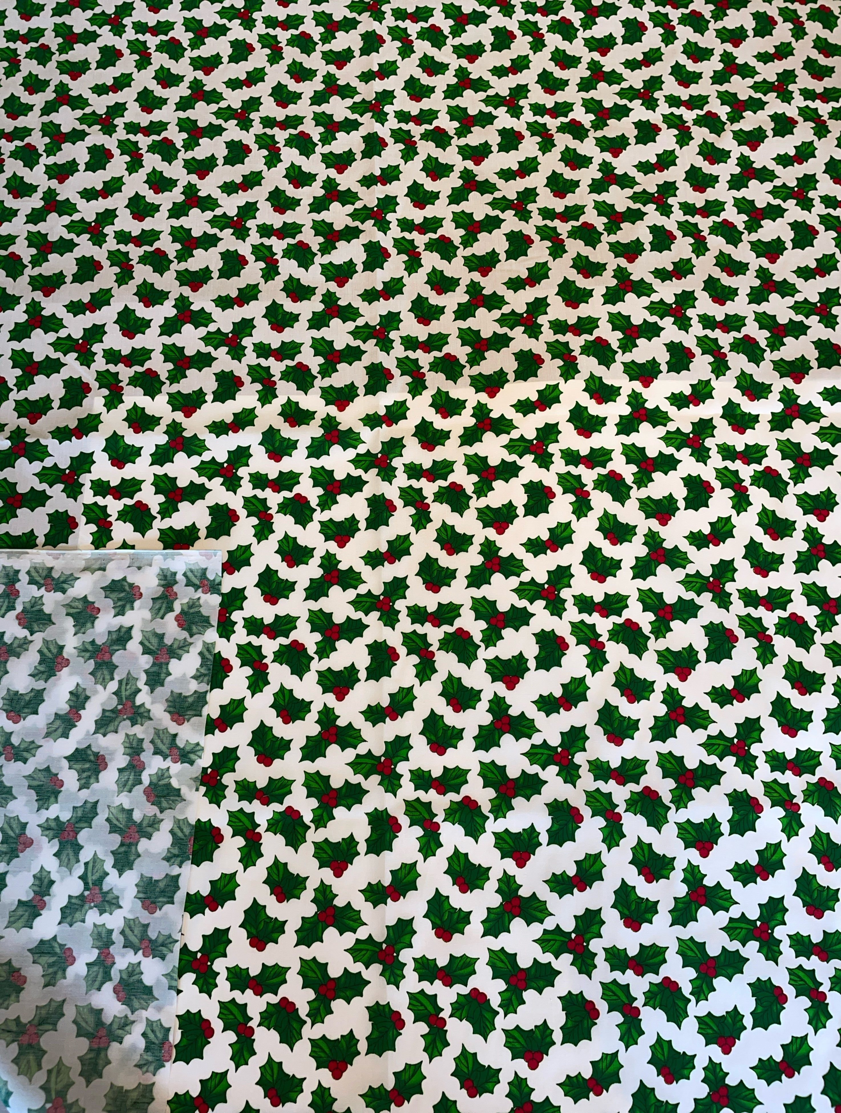 Patterned fabric with holly leaves and berries on a white background