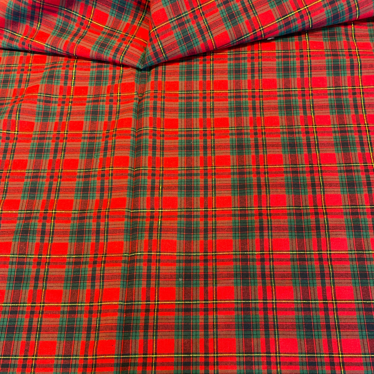 Red tartan plaid fabric with green, yellow, and black stripes, shown folded to display its texture and pattern.