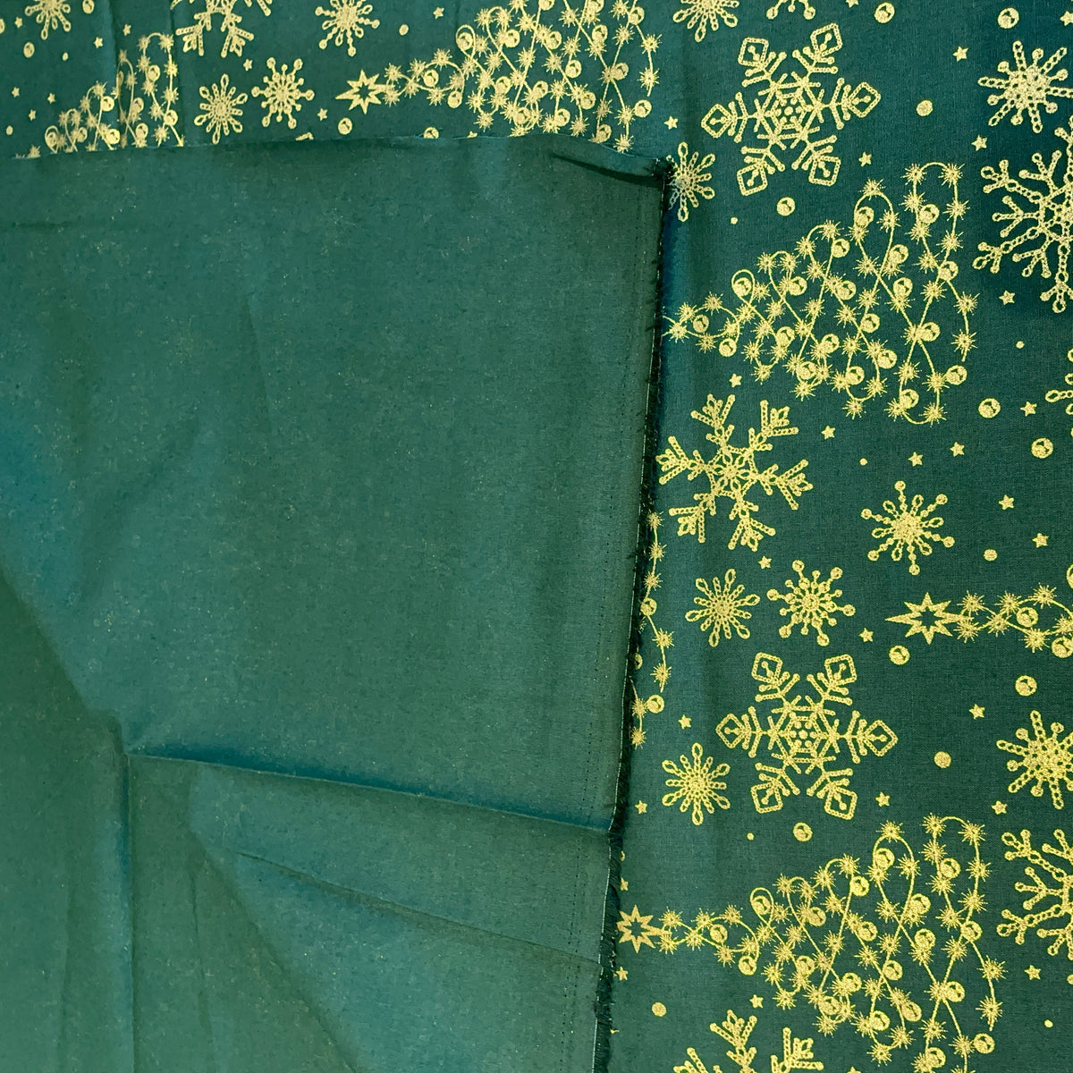 Printed green fabric showing the back of the cotton