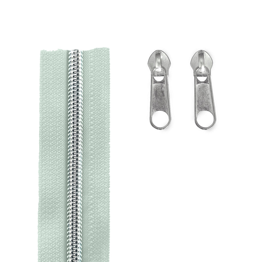 A pale grey silver zipper shown vertically on the left, with two matching silver metal zipper pulls on the right, photographed on a plain white background.