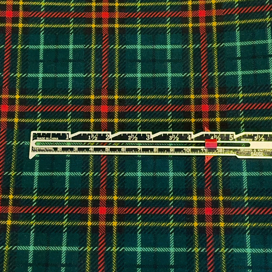 Plaid fabric with a ruler for scale on a green, red, and yellow pattern