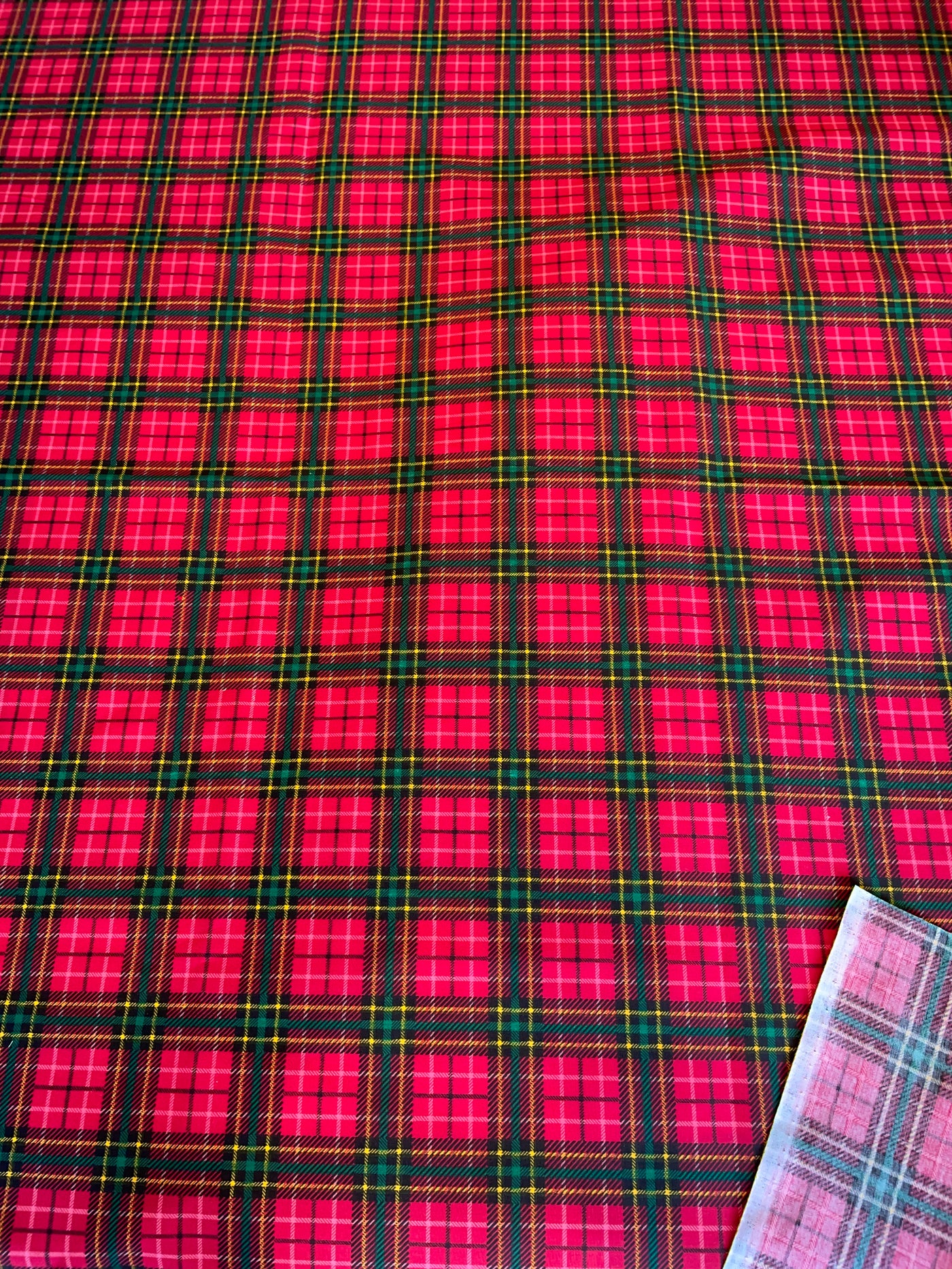 Red and green plaid fabric with a ruler for scale