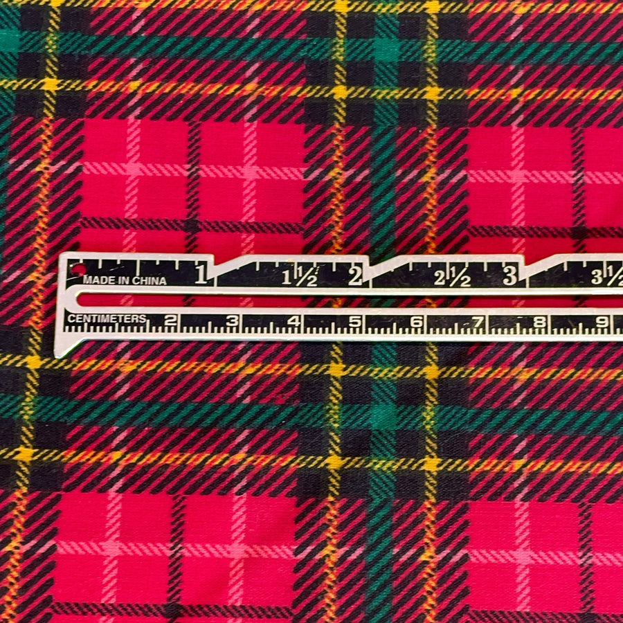Plaid fabric with a ruler for scale on a multicolored plaid pattern