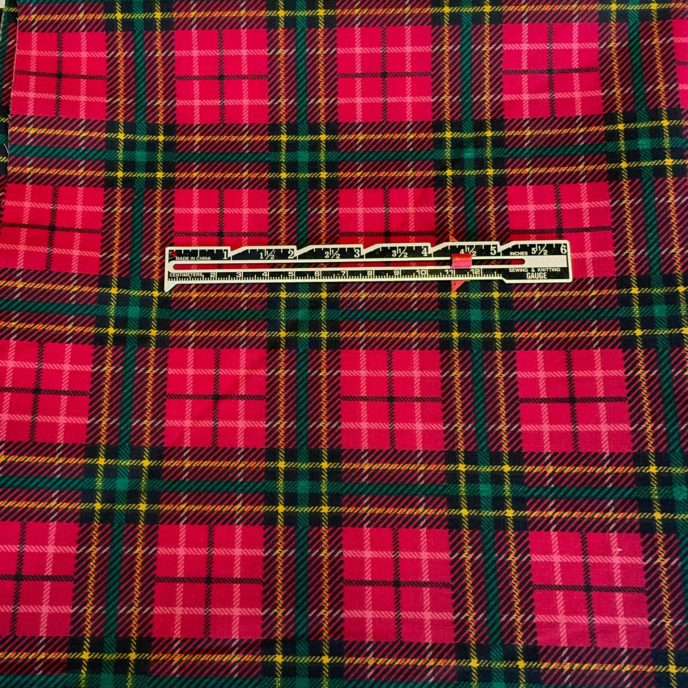 Plaid fabric with red and green pattern and a ruler overlay
