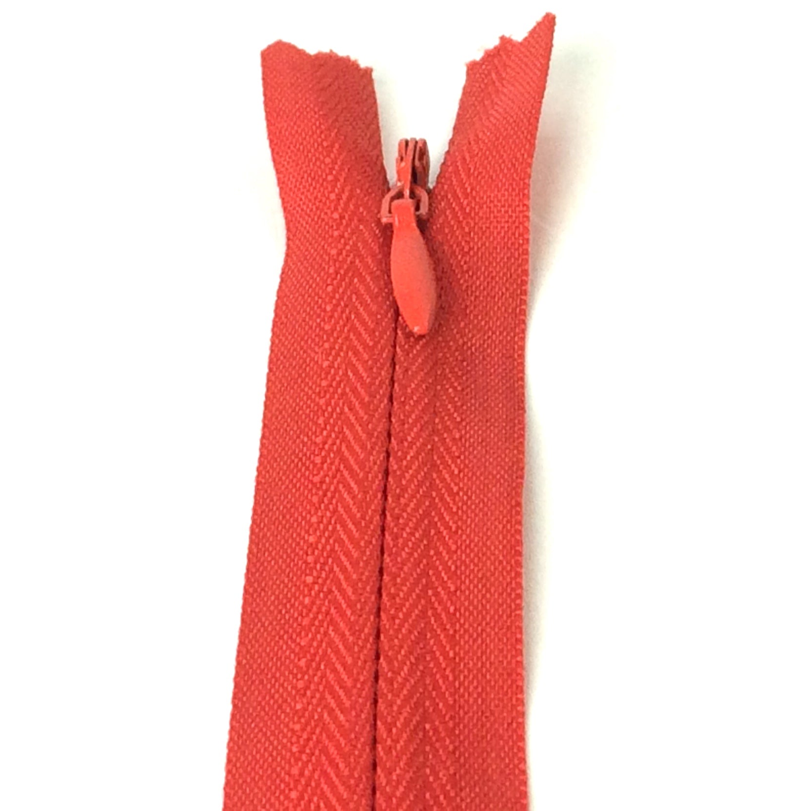 Photo of post box red invisible or concealed zips available in many different colours and sizes. Great for achieving a professional finish in your products. Invisible zippers are perfect for dressmaking, cushions, crafts, etc., where you don't want your zipper showing. Installing them can be tricky without the right foot on your machine; a normal zipper foot is for installing standard zippers, while you will need an invisible zipper foot for a professional result