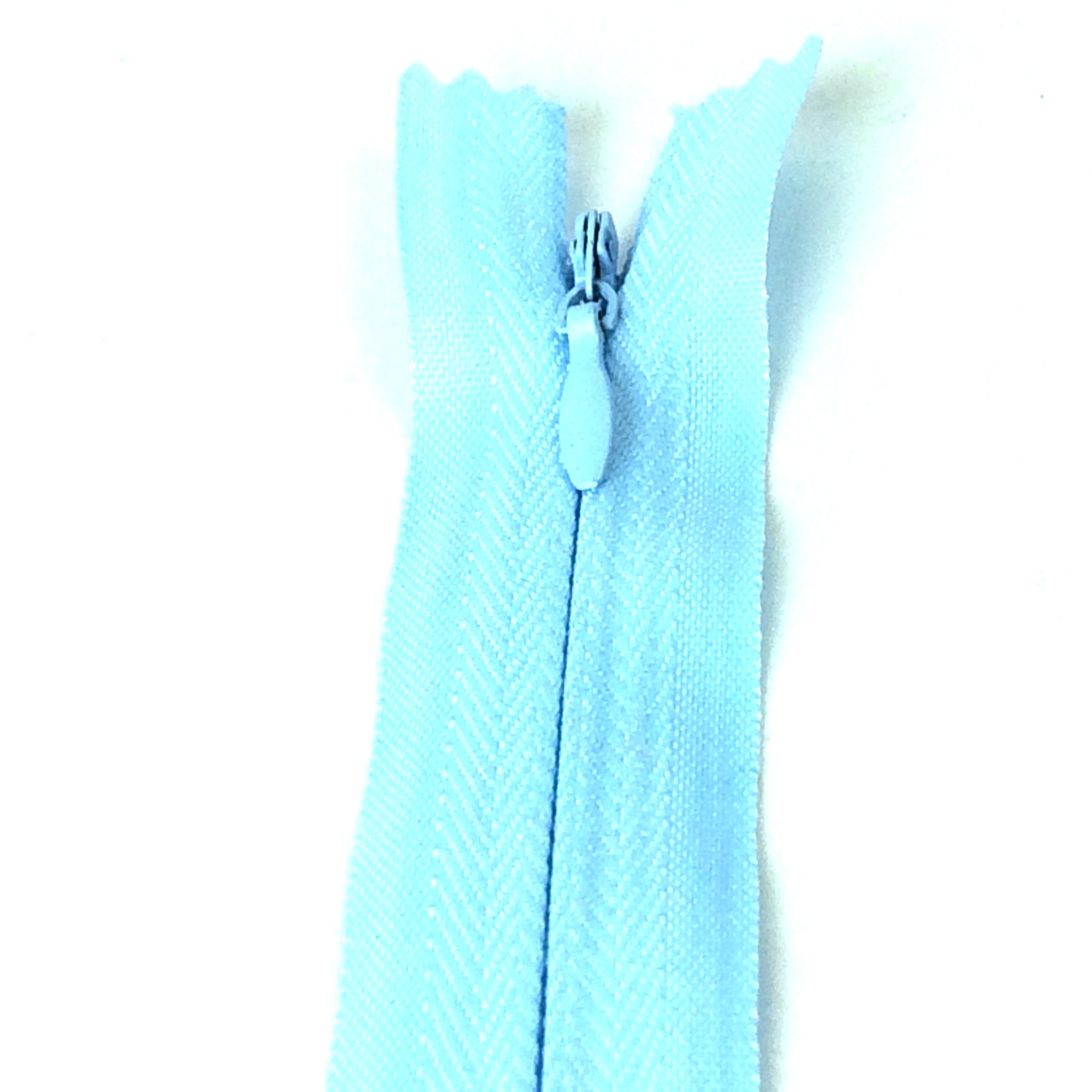 Photo of light blue invisible or concealed zips available in many different colours and sizes. Great for achieving a professional finish in your products. Invisible zippers are perfect for dressmaking, cushions, crafts, etc., where you don't want your zipper showing. Installing them can be tricky without the right foot on your machine; a normal zipper foot is for installing standard zippers, while you will need an invisible zipper foot for a professional result