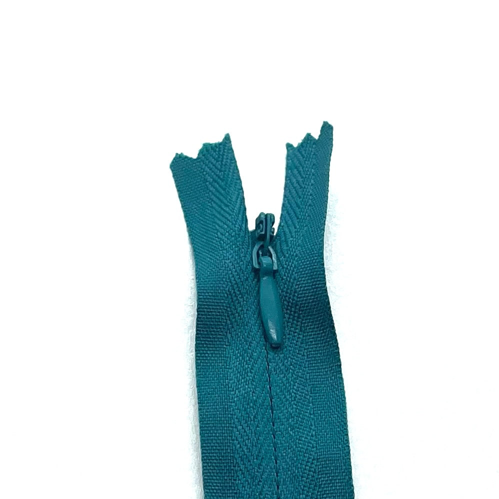 Photo of teal green invisible or concealed zips available in many different colours and sizes. Great for achieving a professional finish in your products. Invisible zippers are perfect for dressmaking, cushions, crafts, etc., where you don't want your zipper showing. Installing them can be tricky without the right foot on your machine; a normal zipper foot is for installing standard zippers, while you will need an invisible zipper foot for a professional result