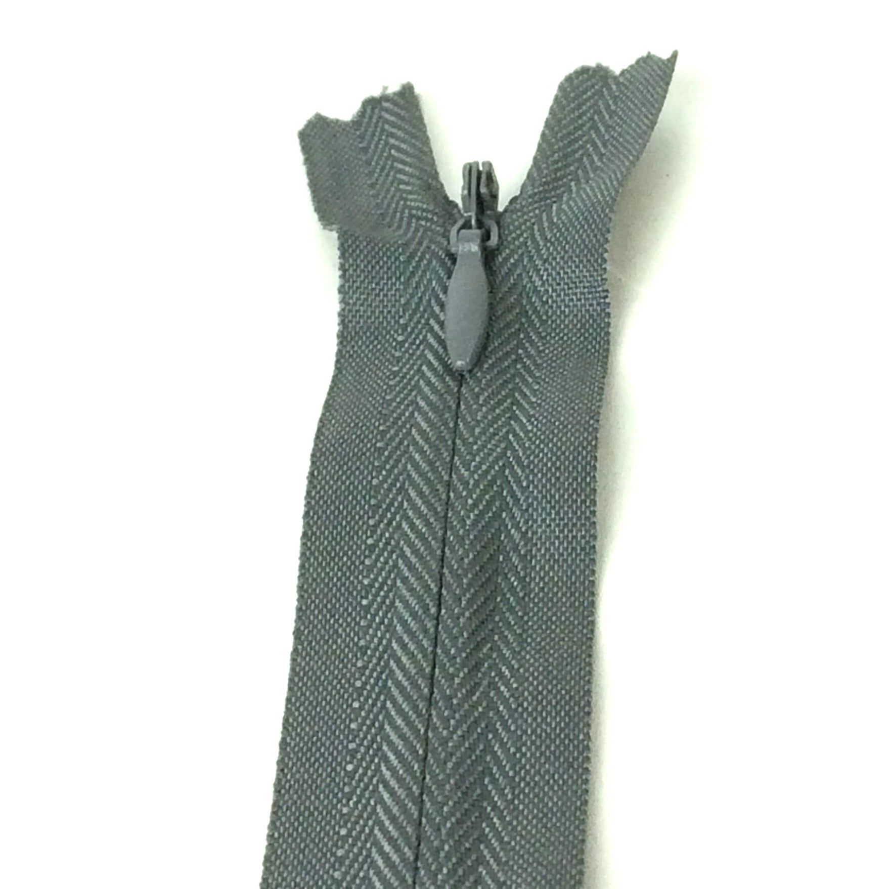 Photo of dark grey invisible or concealed zips available in many different colours and sizes. Great for achieving a professional finish in your products. Invisible zippers are perfect for dressmaking, cushions, crafts, etc., where you don't want your zipper showing. Installing them can be tricky without the right foot on your machine; a normal zipper foot is for installing standard zippers, while you will need an invisible zipper foot for a professional result