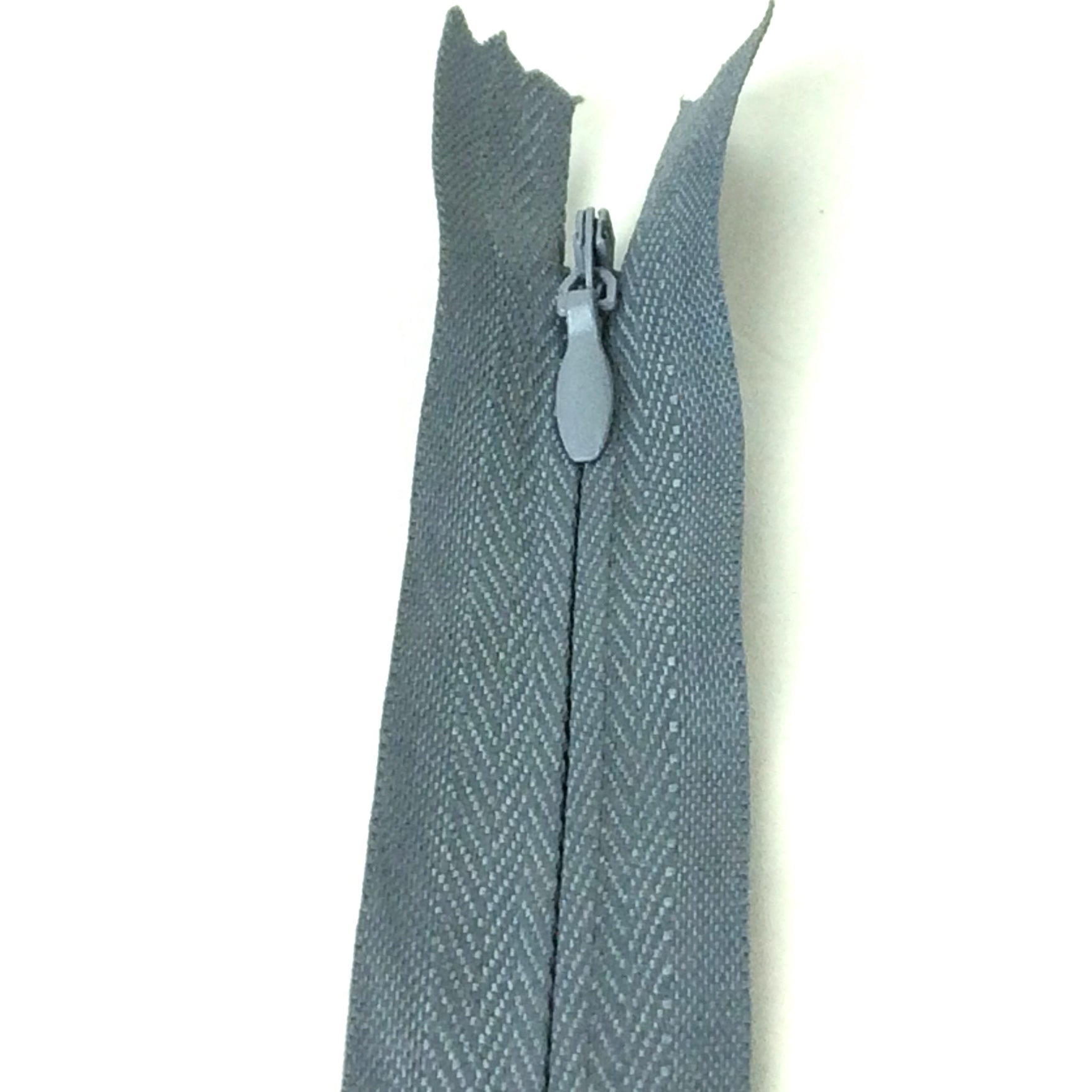 Photo of steel grey invisible or concealed zips available in many different colours and sizes. Great for achieving a professional finish in your products. Invisible zippers are perfect for dressmaking, cushions, crafts, etc., where you don't want your zipper showing. Installing them can be tricky without the right foot on your machine; a normal zipper foot is for installing standard zippers, while you will need an invisible zipper foot for a professional result
