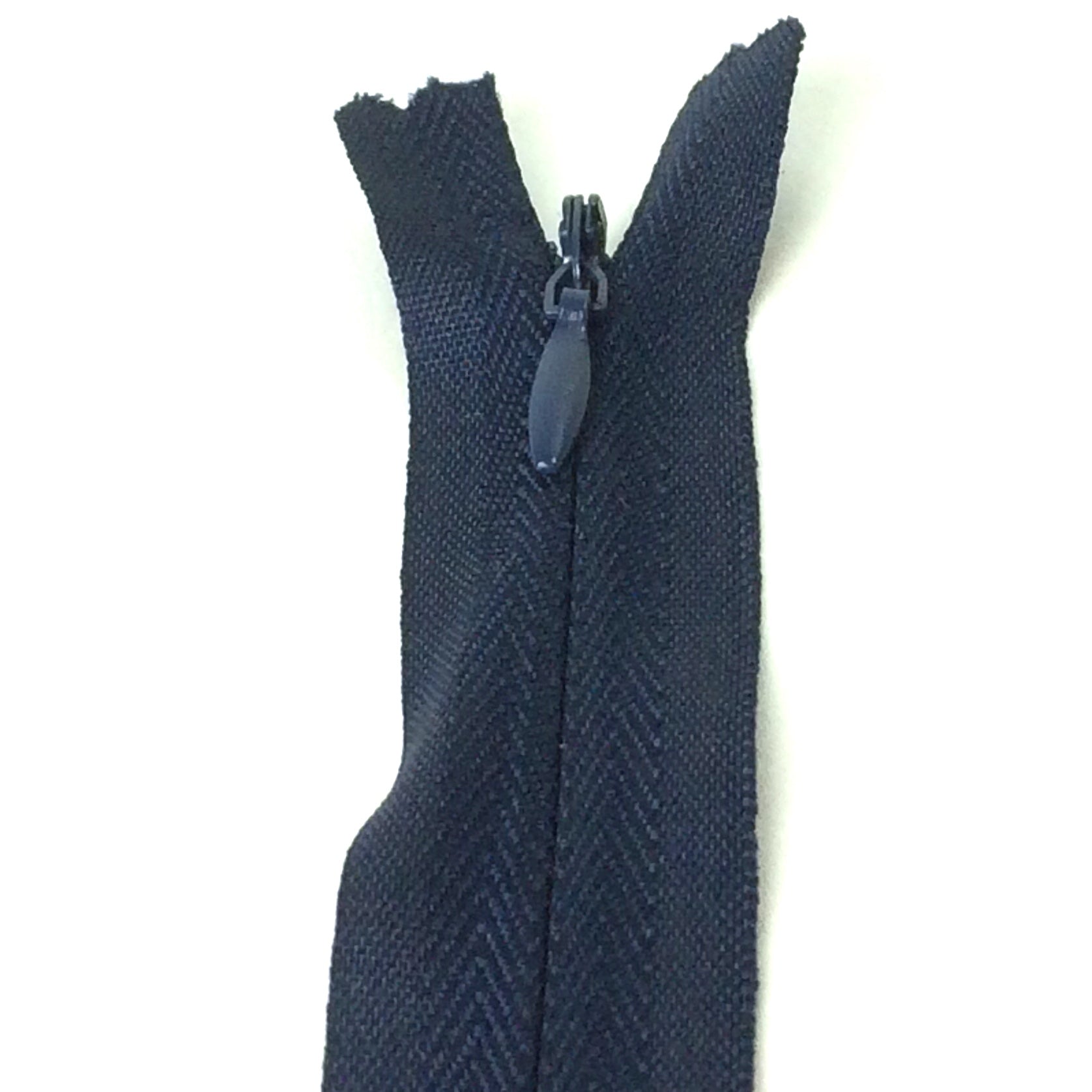 Photo of navy blue invisible or concealed zips available in many different colours and sizes. Great for achieving a professional finish in your products. Invisible zippers are perfect for dressmaking, cushions, crafts, etc., where you don't want your zipper showing. Installing them can be tricky without the right foot on your machine; a normal zipper foot is for installing standard zippers, while you will need an invisible zipper foot for a professional result