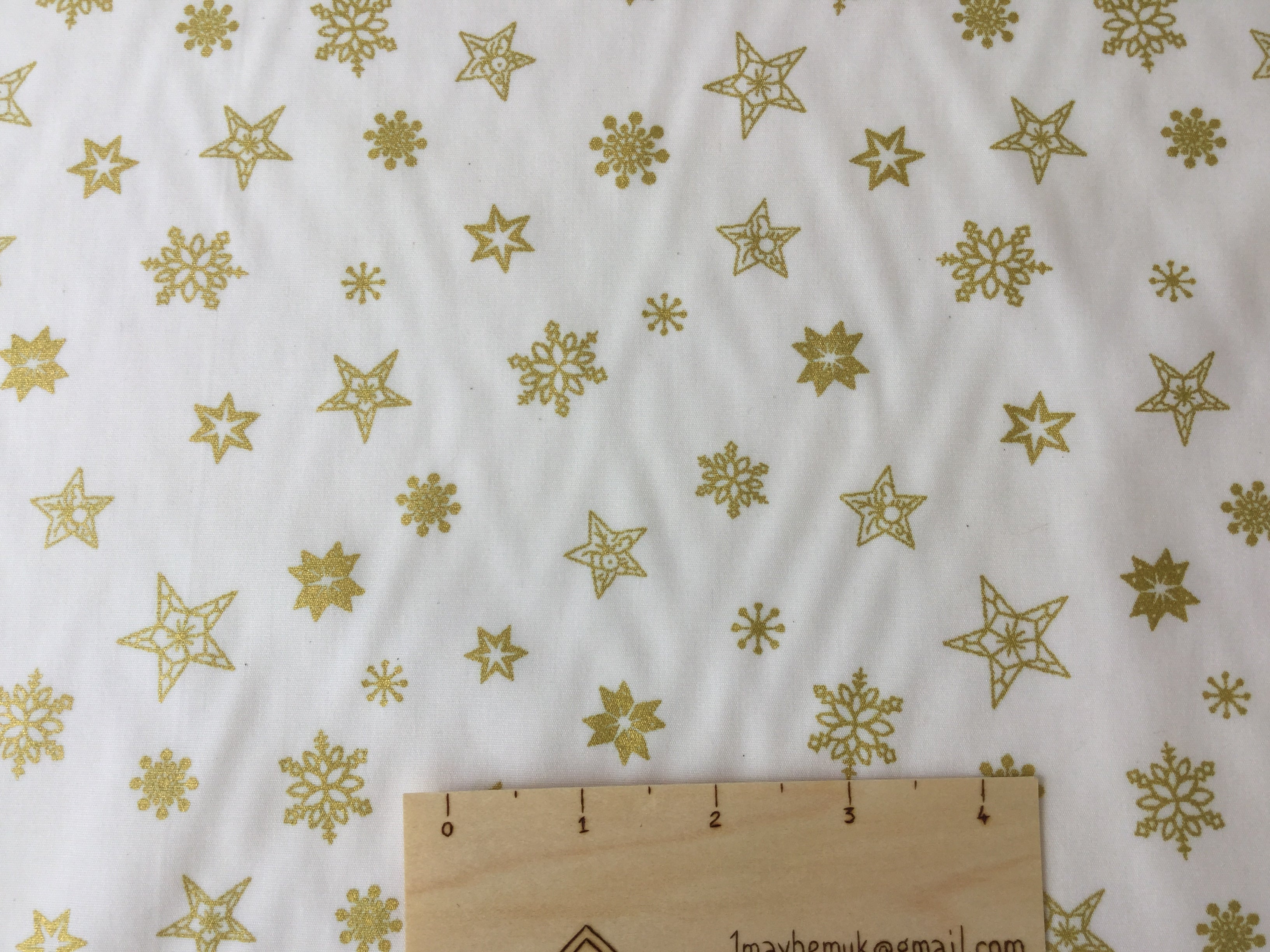 Rose and hubble gold stars cotton fabric with a festive theme