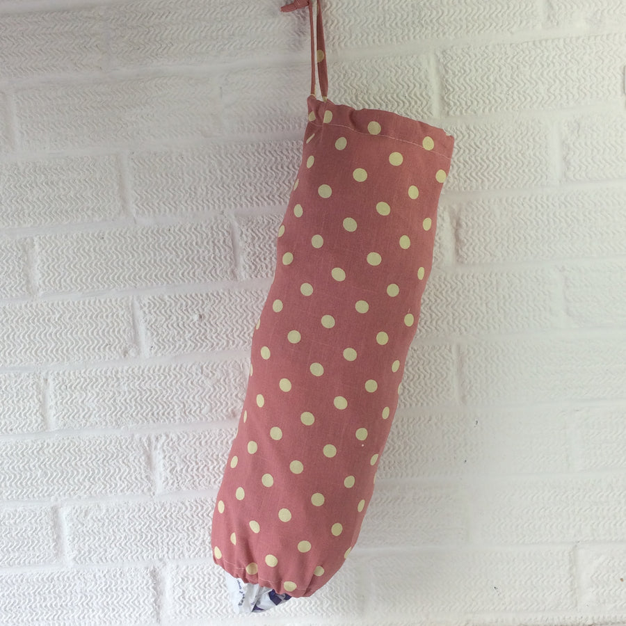 Plastic bag dispenser, dusky pink with large spots and a draw string