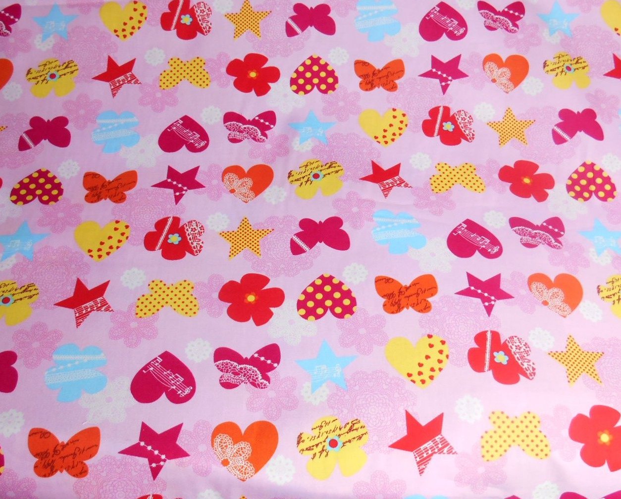 A rose and hubble cotton fabric with butterflies and stars on a pink background
